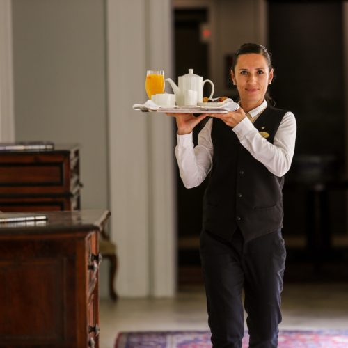 Room Service Breakfast at The Xara Palace Relais Chateaux. A waitress delivering breakfast to the room